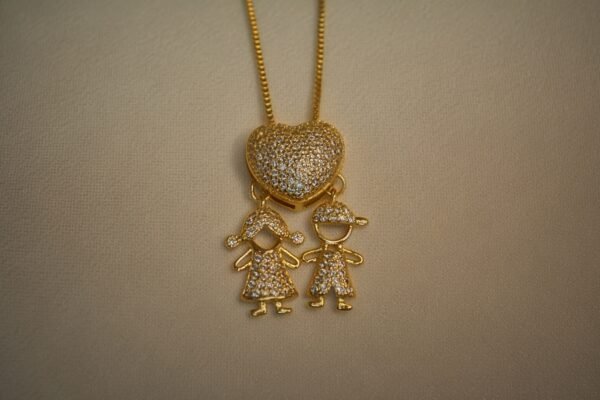 a gold necklace with a couple of children on it